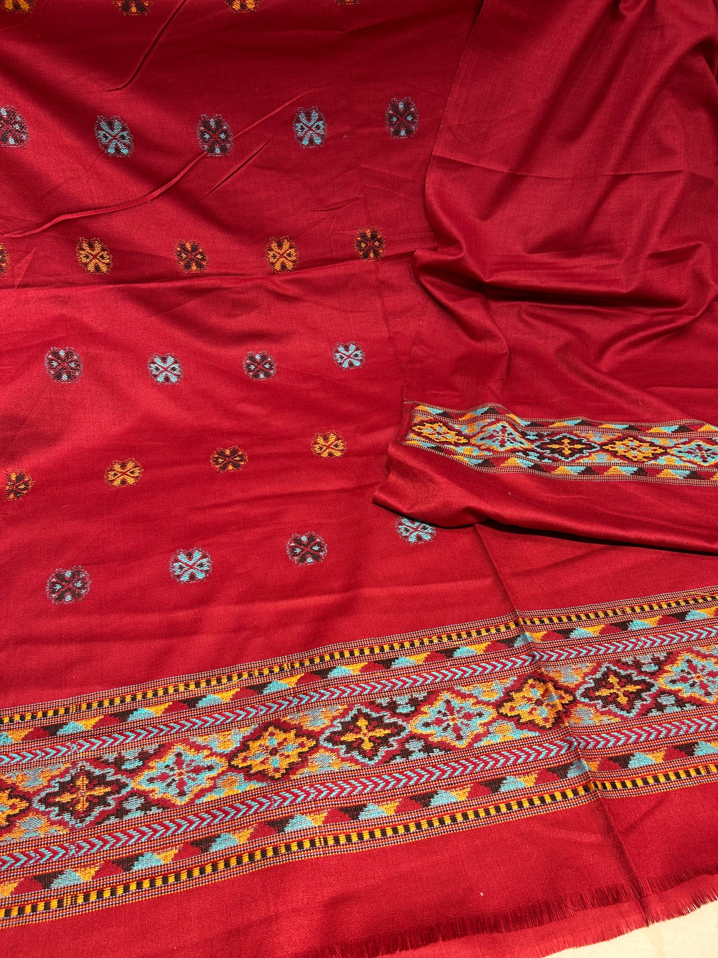 Red fabric with intricate patterns and embroidery